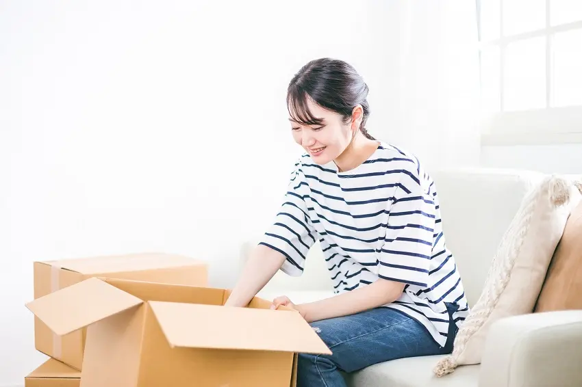 ダンボールを開ける女性